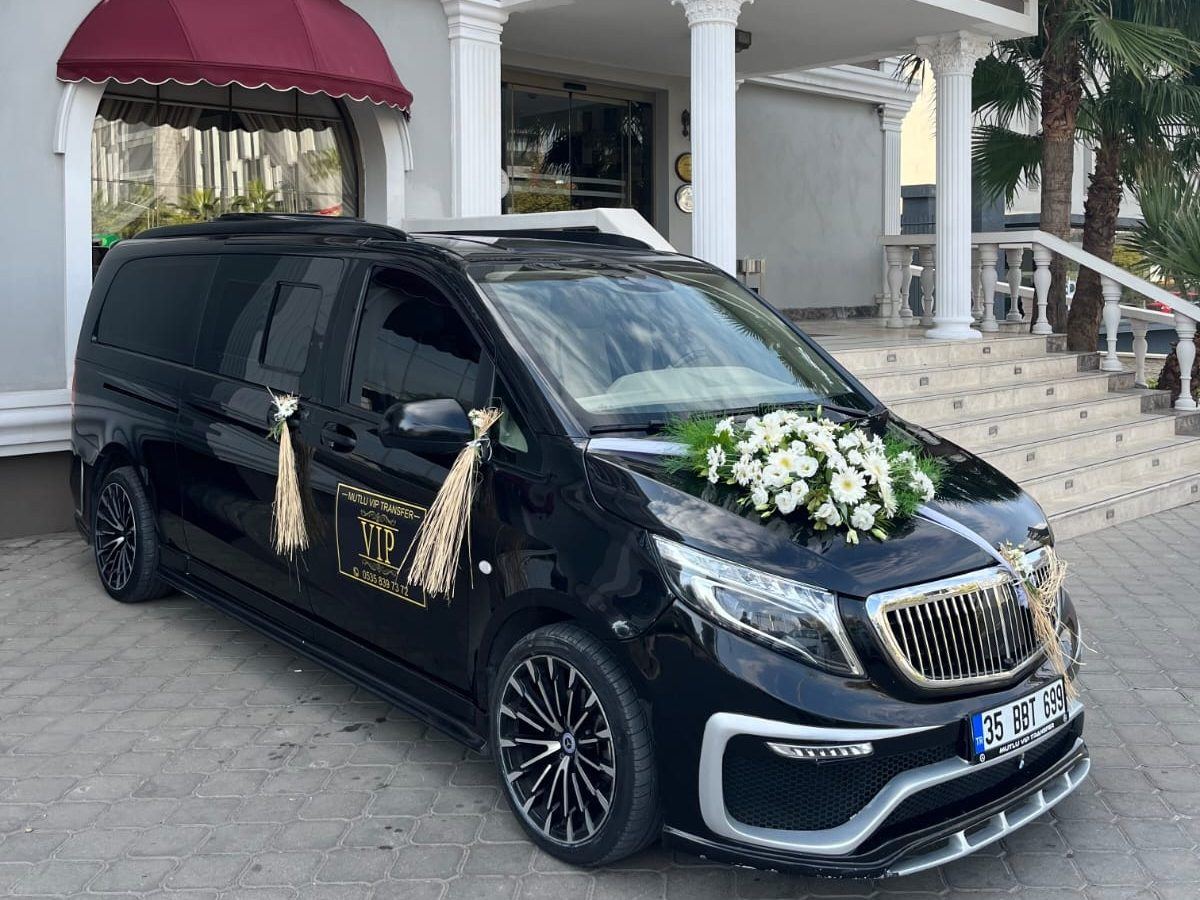 Çiçeklerle süslenmiş siyah Mercedes Vito gelin arabası düğün salonu önünde